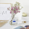 Vase méduse conique posé sur un bureau avec un bouquet de fleur dedans