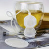 Infuseur thé plongeur devant une tasse de thé
