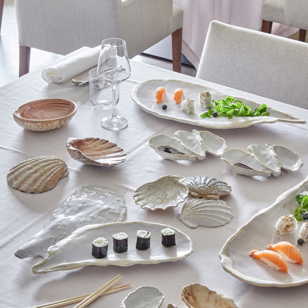 Élégante table avec de la belle vaisselle et des assiettes en forme d'huître